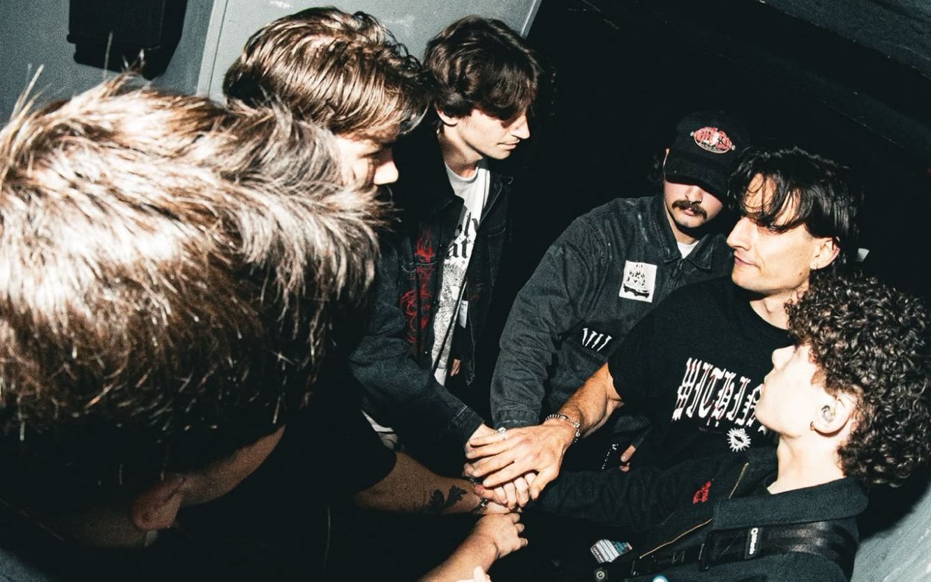 Band with hands in together backstage before a show