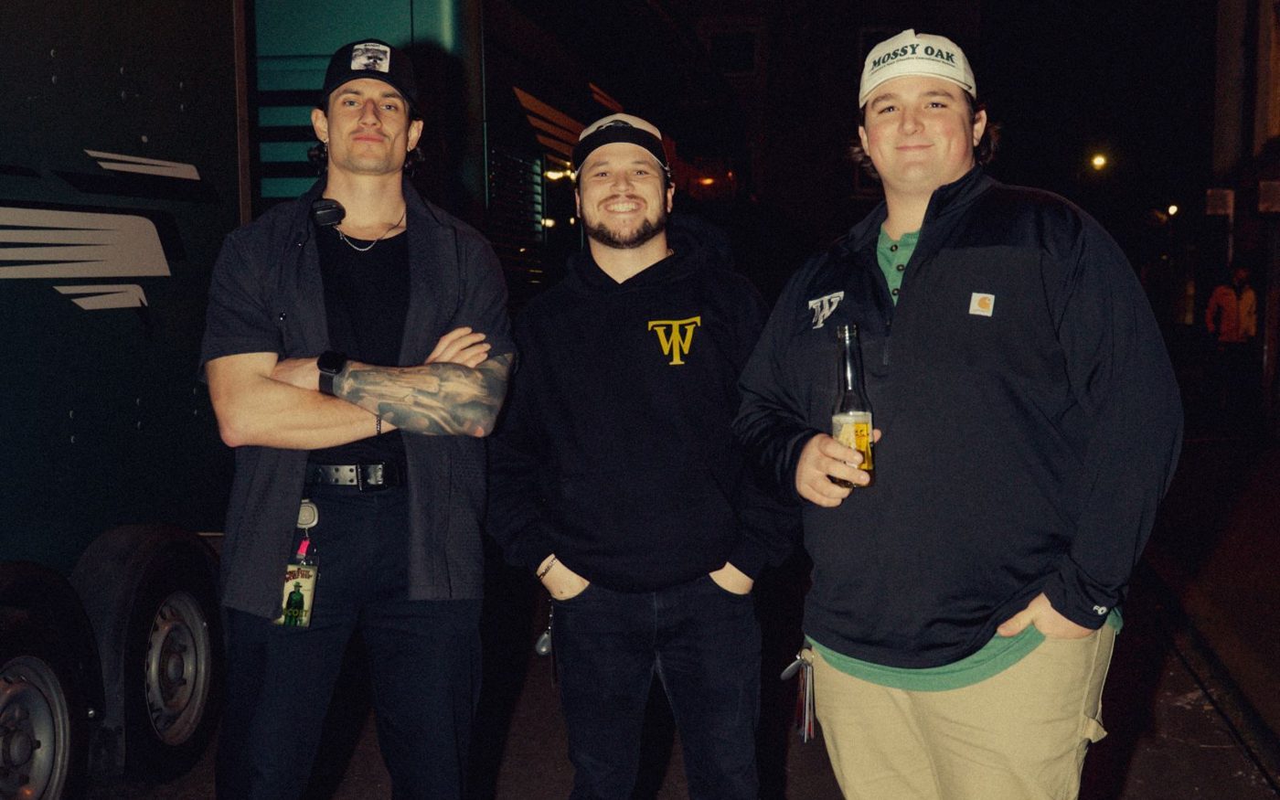 Touring crew outside the tour bus at night
